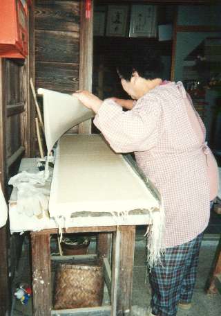 Mrs. Fukunishi carefully lifts a sheet of this fragile paper